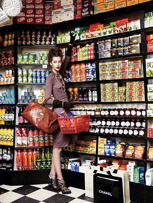 a woman standing in front of a store display filled with drinks and juices on shelves