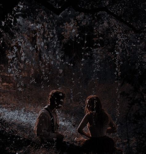 two people sitting in the woods at night