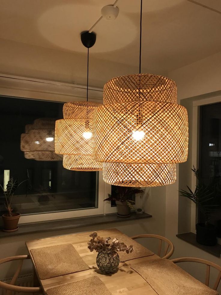 a wooden table and chairs under a light fixture