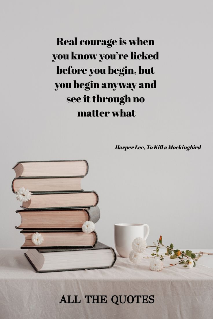 a stack of books sitting on top of a table next to a cup