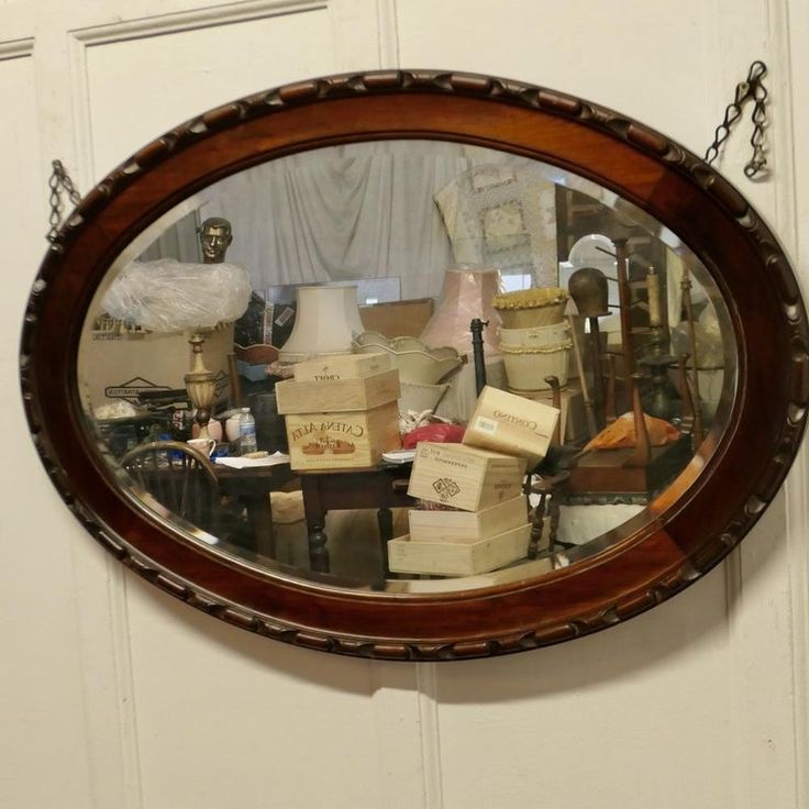 a mirror that is on the wall above a table with boxes and other items in it