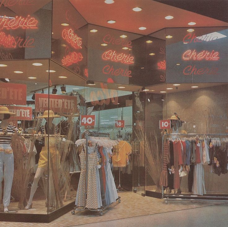 a clothing store with mannequins and neon signs in the window displays clothes