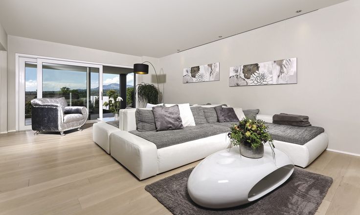 a living room filled with white furniture and lots of glass doors leading to an outside patio