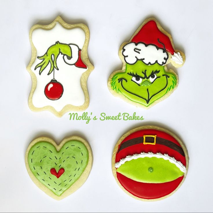 decorated cookies in the shape of grin's christmas hats and other holiday treats are arranged on a white surface