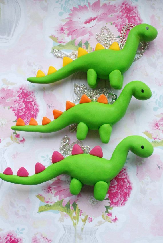 two green plastic dinosaurs sitting next to each other