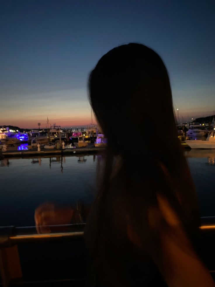 a woman looking out over the water at night