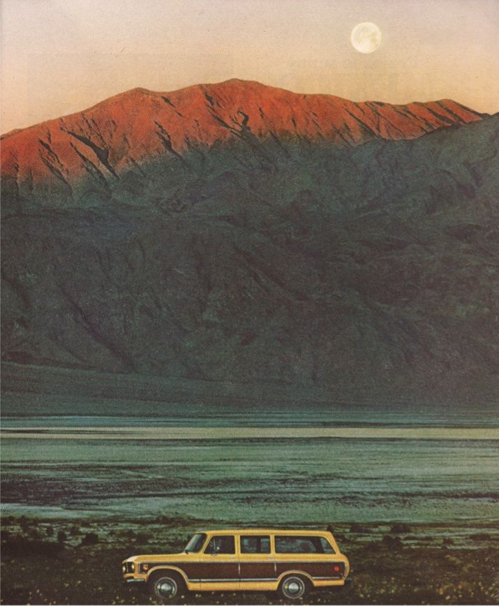 an old car is parked in front of a mountain with a full moon behind it