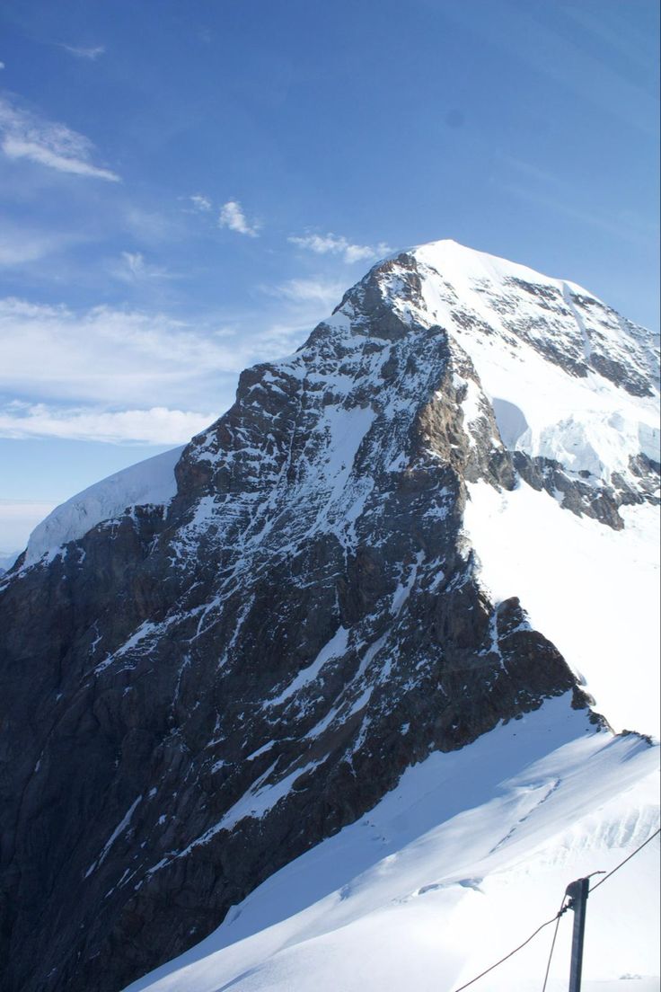 a man riding skis down the side of a snow covered mountain