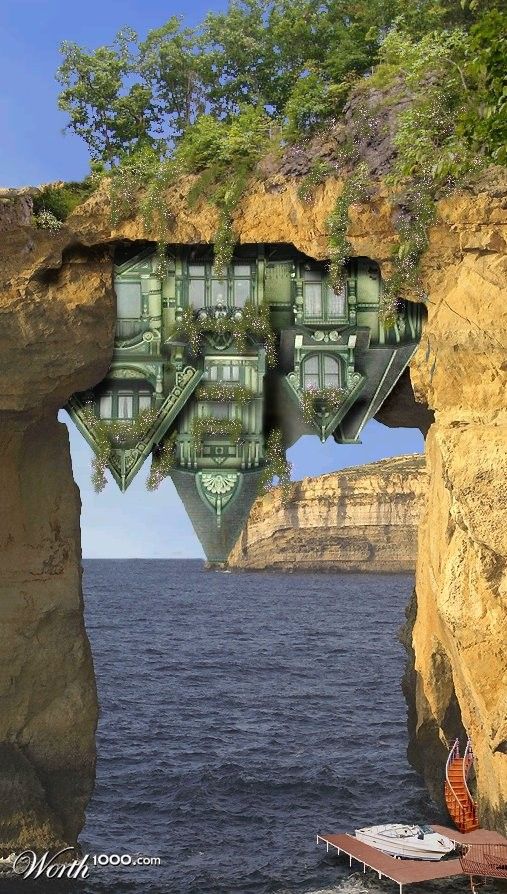 a boat floating on top of a body of water next to a cliff with a house built into it