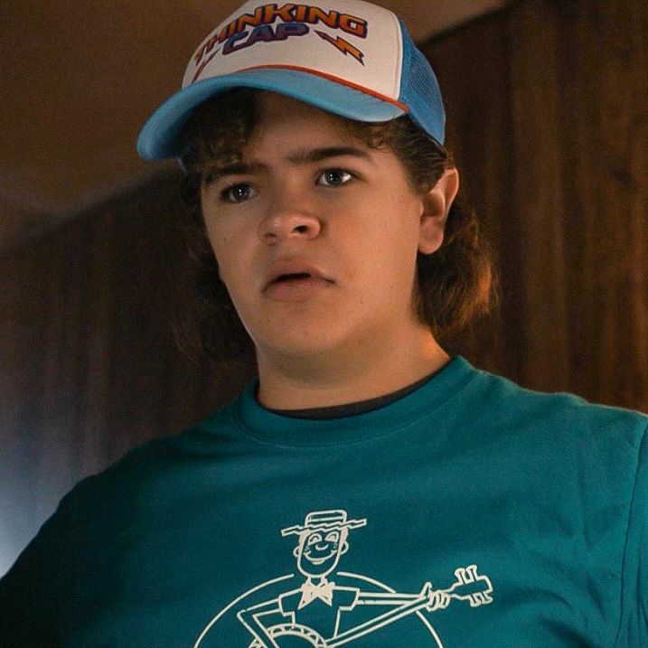 a young boy wearing a blue shirt and hat