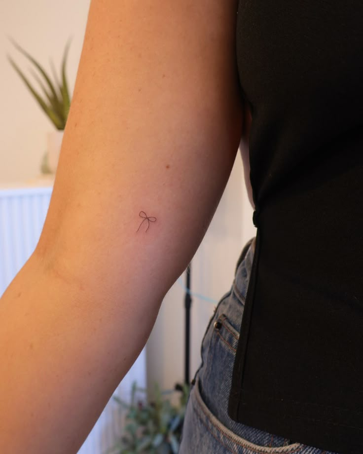 a woman's arm with a small tattoo on the left side of her arm