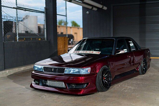 a maroon car parked in front of a garage