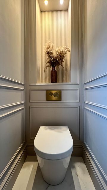 a white toilet sitting in a bathroom next to a plant