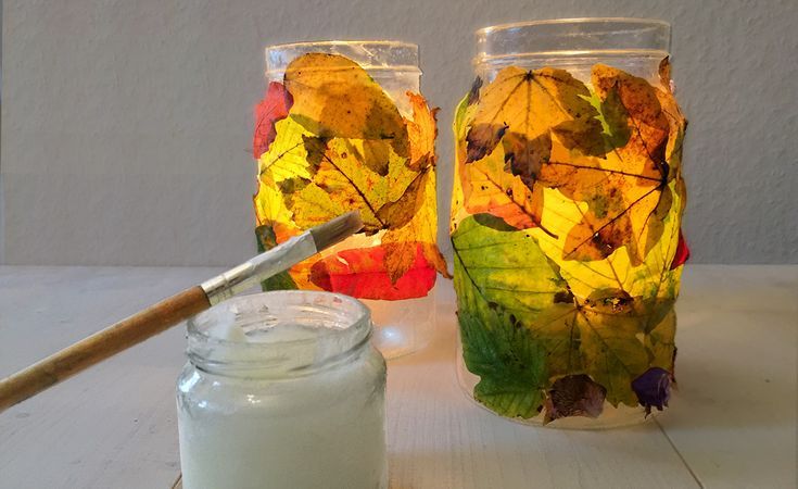 two jars filled with leaves next to each other