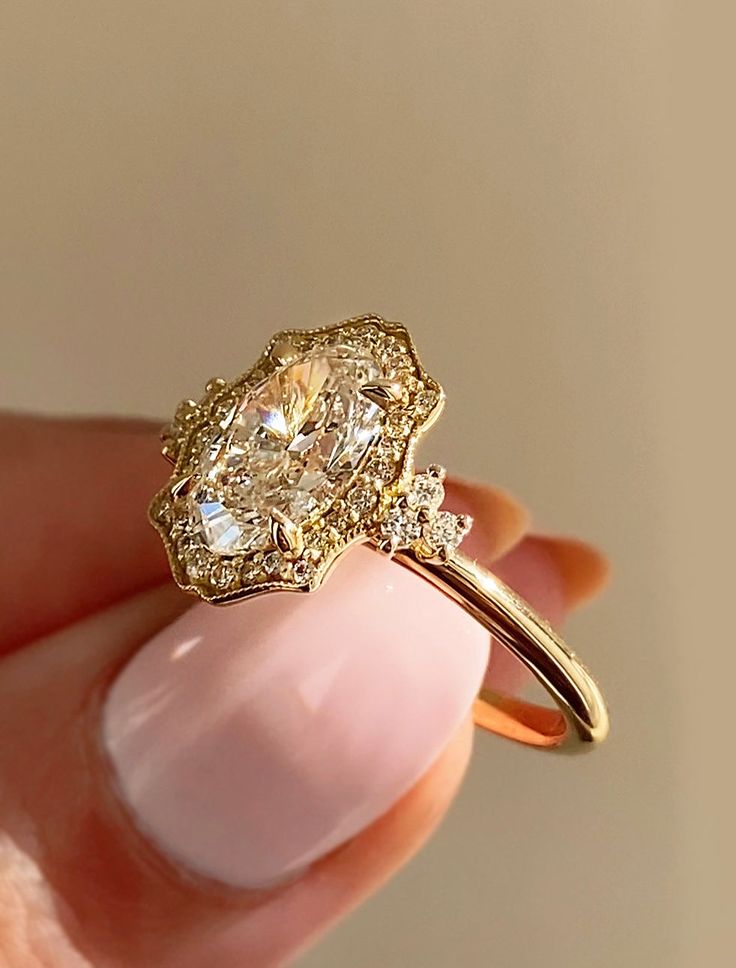 a woman's hand holding an engagement ring with two diamonds on the top and bottom