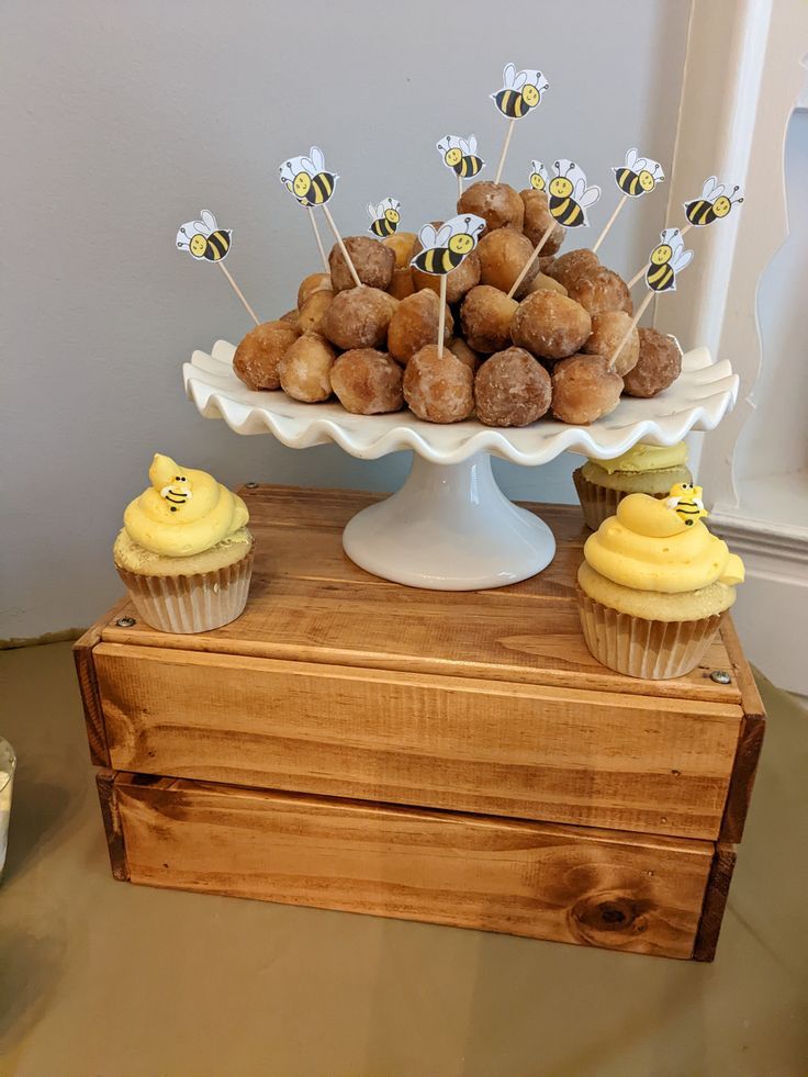 there is a cake and cupcakes on the table with honeycombs in it