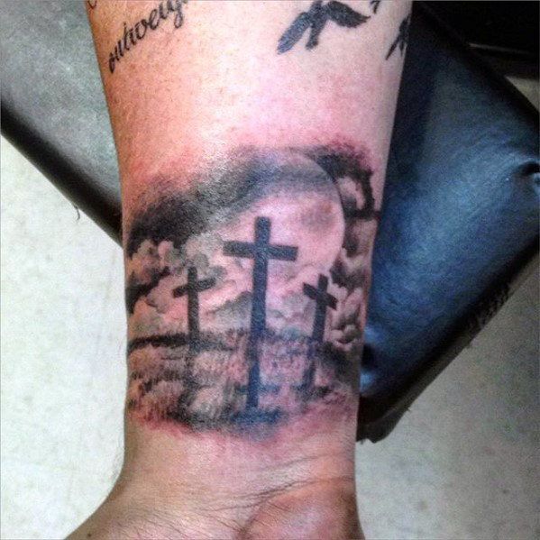 a person with a cross tattoo on their arm