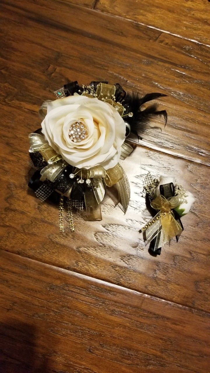 a wooden table topped with flowers and brooches on top of wood flooring