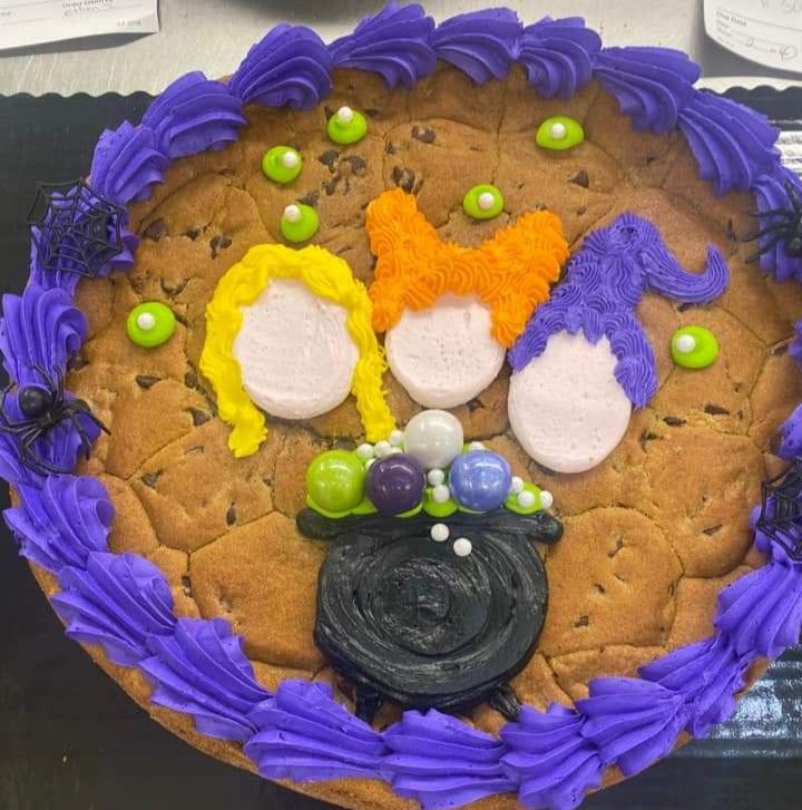 a decorated cookie with purple icing and decorations