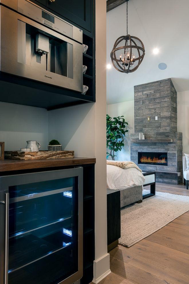 a bedroom with a fireplace and built in entertainment center next to a living room area