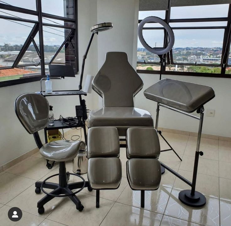 an office with chairs and desks in front of large windows, overlooking the city