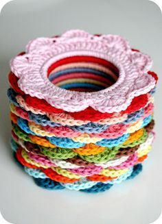 a stack of crochet coasters sitting on top of each other in different colors