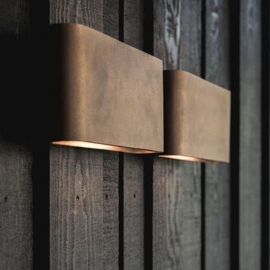 two lights on the side of a wooden wall