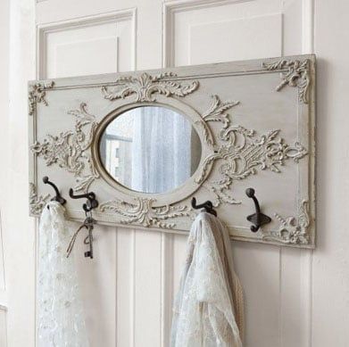 an ornate mirror hangs on the wall next to two white towels and a towel rack