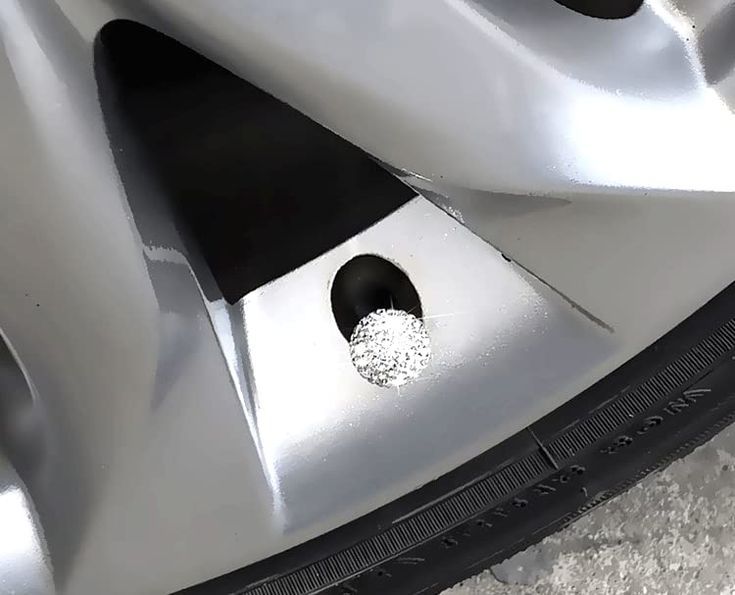 a close up of a car tire with two holes in the center and one hole on the side