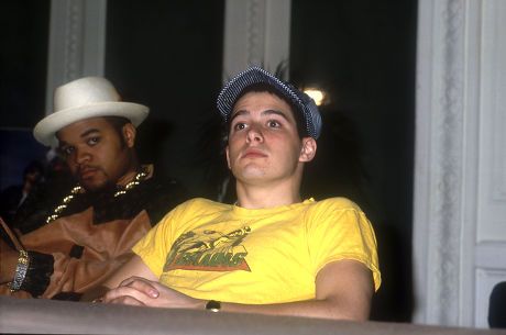 two men sitting next to each other wearing hats