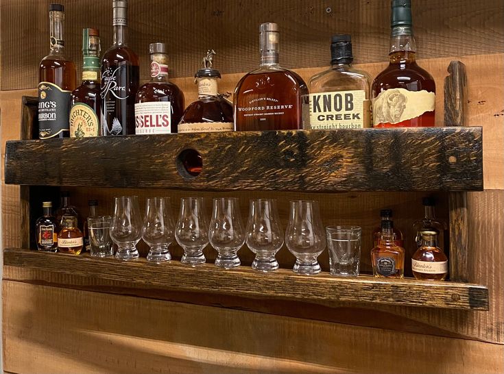 several bottles and glasses are lined up on a shelf