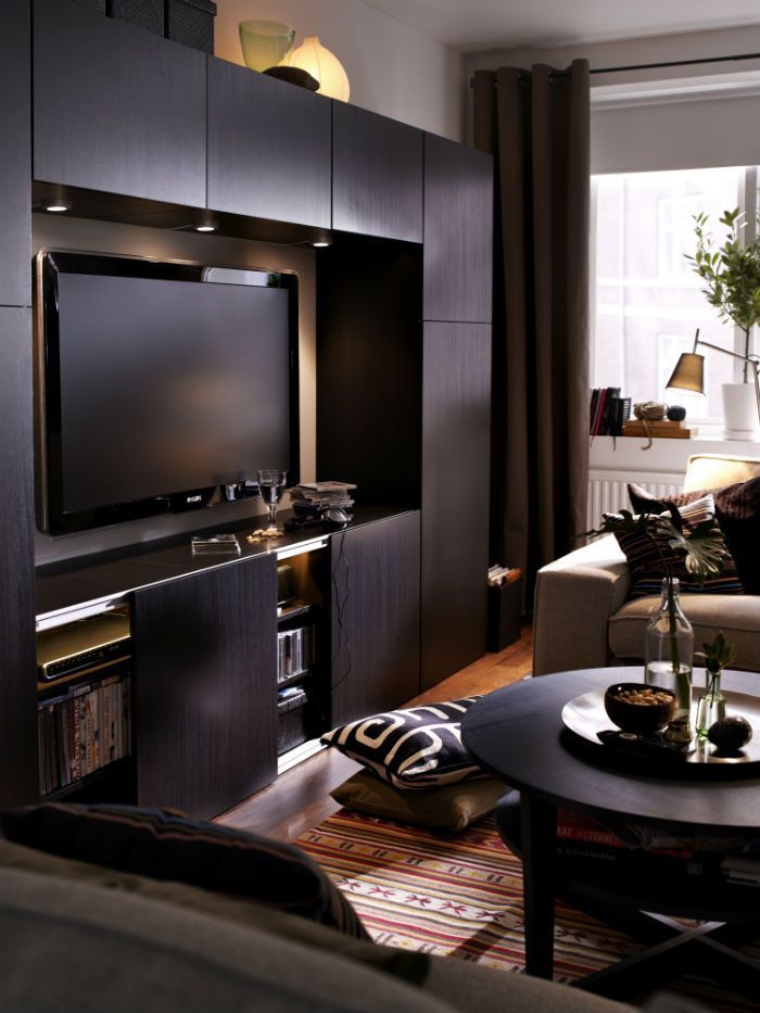 a living room filled with furniture and a flat screen tv on top of a entertainment center