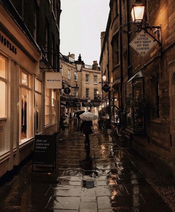 people walking down an alley way in the rain