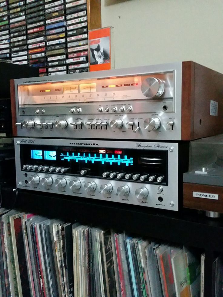 an old fashioned radio sitting on top of a shelf filled with cd's and cds