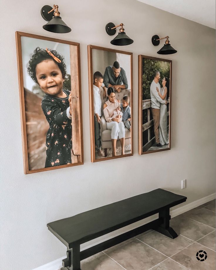 three framed pictures hang on the wall above a bench in a room with tile flooring