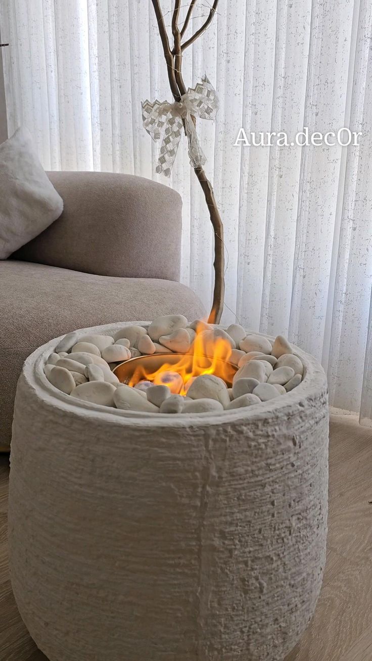 a fire pit sitting on top of a hard wood floor next to a couch and window