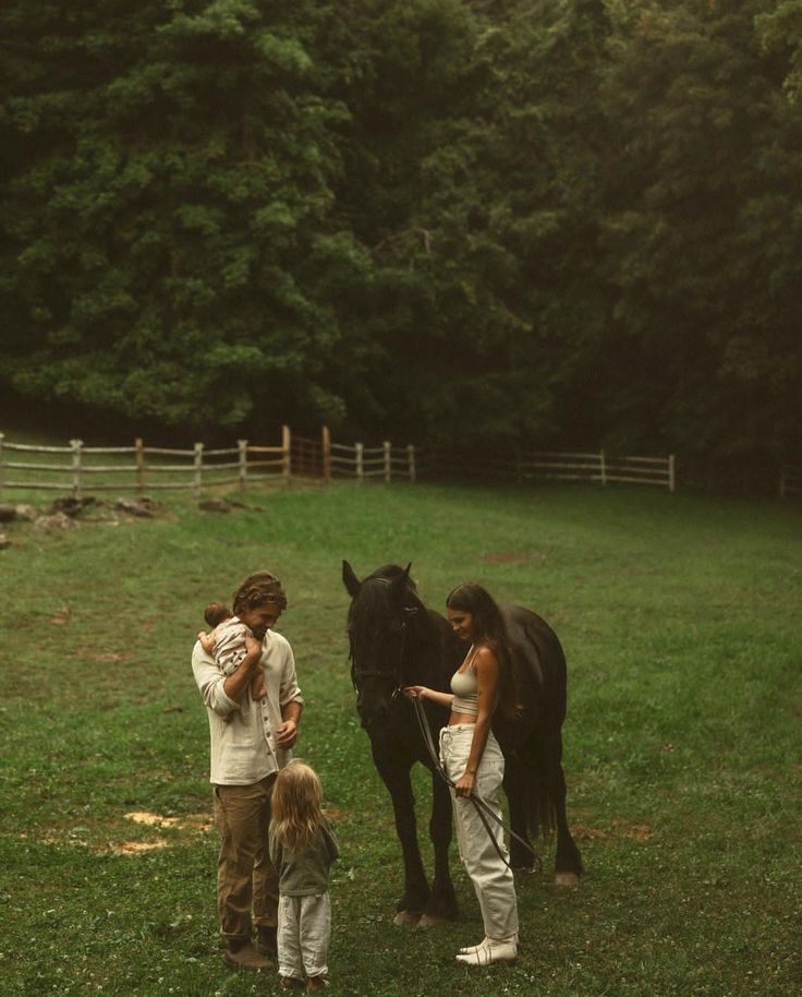 two women and a child standing next to a horse