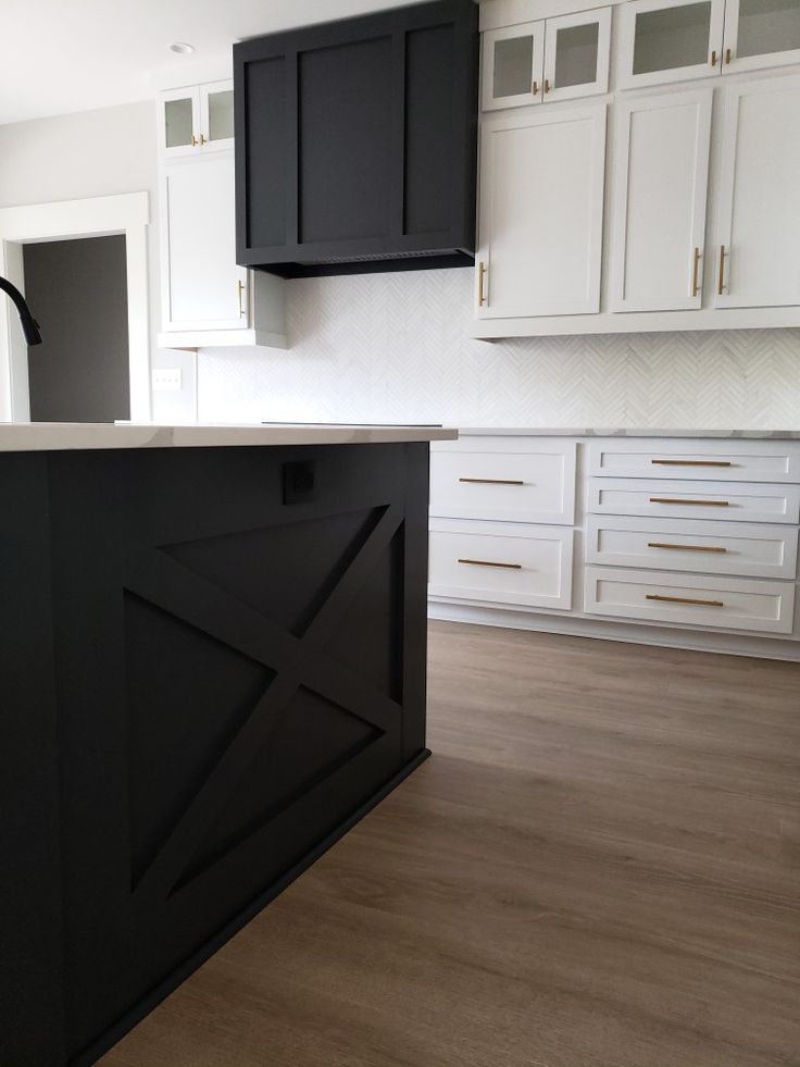 an empty kitchen with black cabinets and white counter tops, is pictured in this image