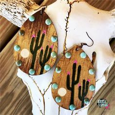 two wooden earrings with cactus designs on them are shown in an instagramting post