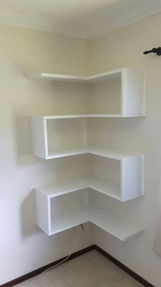 a corner shelf in the corner of a room with tile flooring and white walls