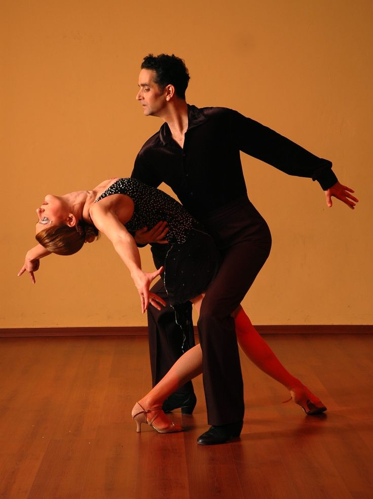 a man and woman are dancing together on the dance floor in an empty room with wooden floors