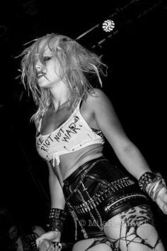 black and white photograph of a woman in punk clothing with her hands on her hips