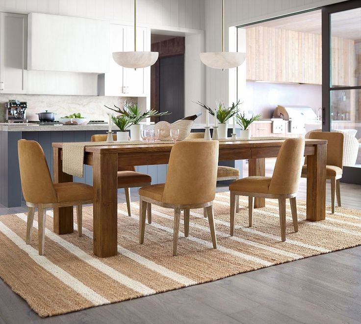 a dining room table with chairs and a rug