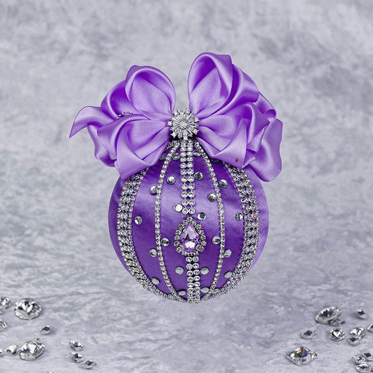 a purple ornament with a bow on it