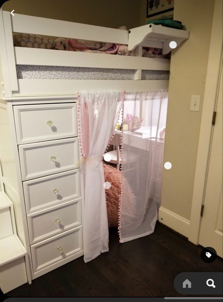 a white bunk bed sitting next to a dresser under a window with pink curtains on it