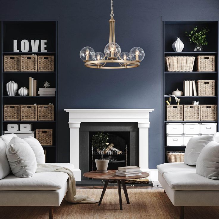 a living room filled with furniture and a fire place under a chandelier in front of a fireplace