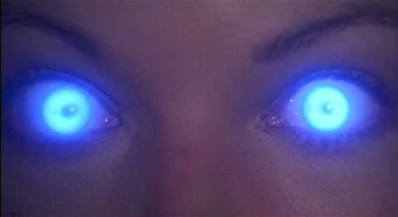 a woman's eyes with glowing blue lights in the middle of their irises