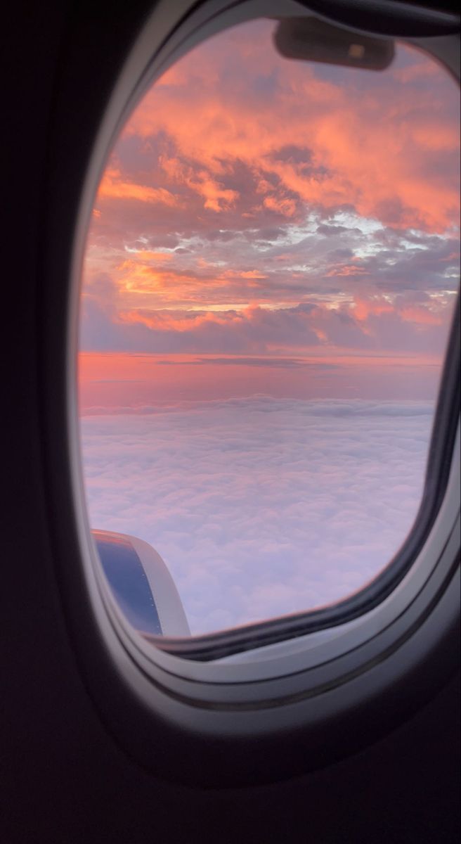 the view out an airplane window at sunset