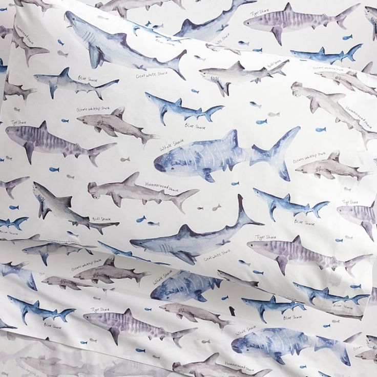 a bed with blue and white sharks on it