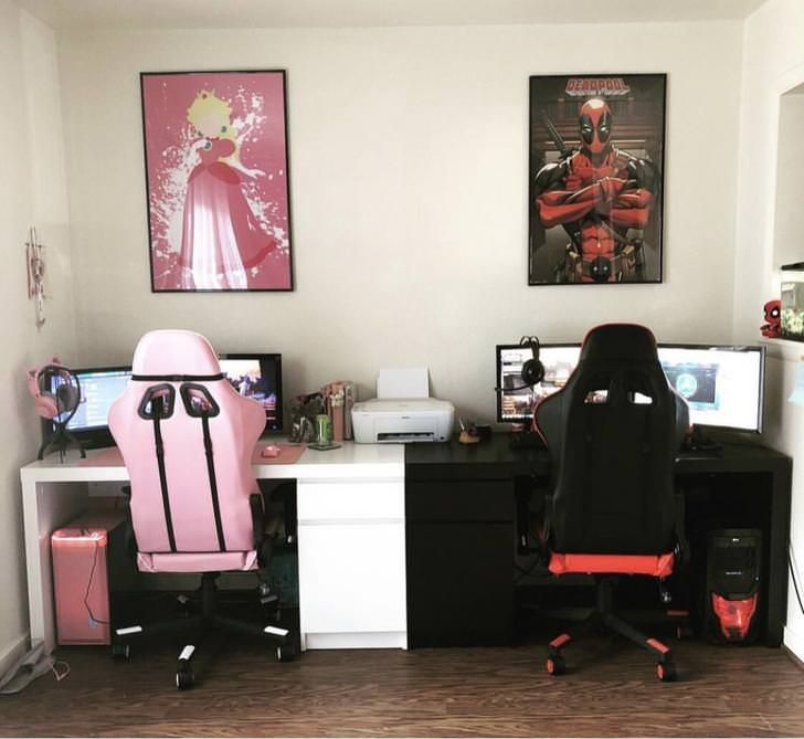 two computer desks with pink chairs and pictures on the wall